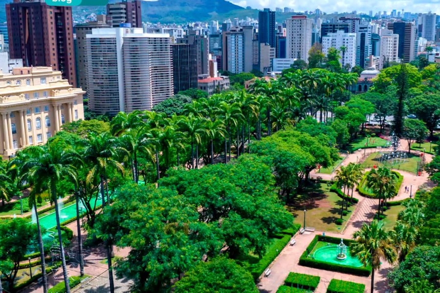 Um parque municipal com árvores e uma fonte no meio.